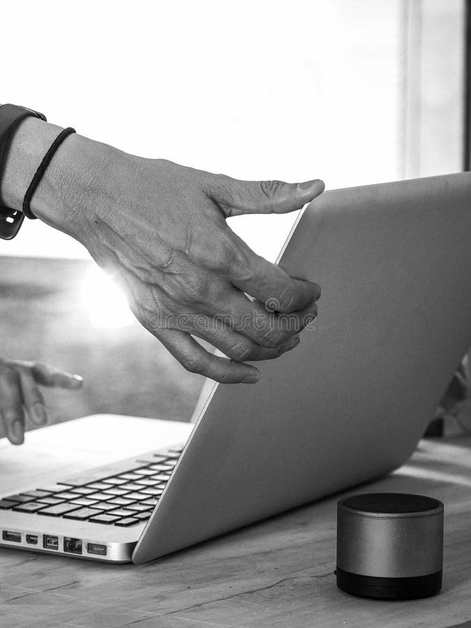 Grayscale vertical shot of a person using a laptop for office work royalty free stock photos