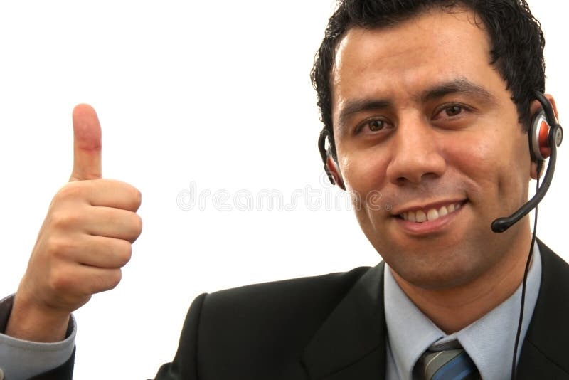 Handsome Male Customer Service answering the phone while giving an thump up with his hand The photo was shot in studio lights. Handsome Male Customer Service answering the phone while giving an thump up with his hand The photo was shot in studio lights