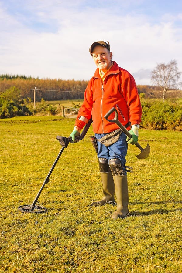 Senior nel bel tempo su terreni agricoli con il rivelatore e picche sperando di trovare oggetti storici e il tesoro perduto.