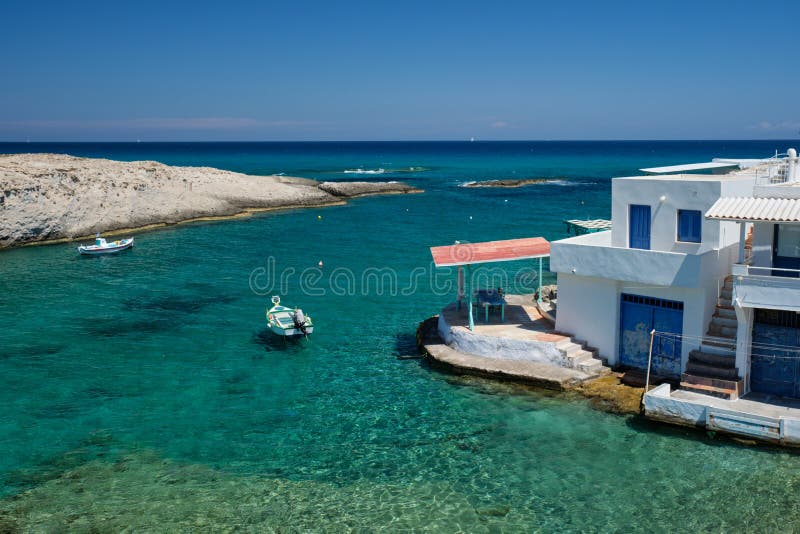 Greece island Milos. Small harbor with fishing boats in water, whitewashed house. Mitakas village. Greece scenic island view - small harbor with fishing boats in royalty free stock photo Greece island Milos. Small harbor with fishing boats in water, whitewashed house. Mitakas village. Greece scenic island view - small harbor with fishing boats in royalty free stock photo