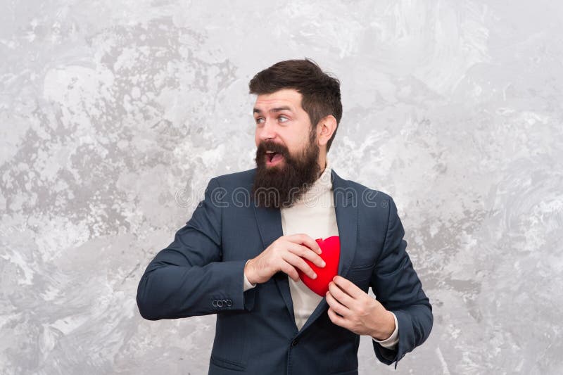 Greedy man hiding feelings. Feast of Saint Valentine. Handsome confident man hold red heart. Businessman love symbol royalty free stock photo Greedy man hiding feelings. Feast of Saint Valentine. Handsome confident man hold red heart. Businessman love symbol royalty free stock photo