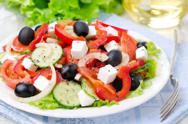 Greek salad with feta cheese, olives and vegetables on the plate