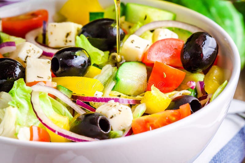 Greek salad of organic tomatoes, cucumber, red onion, olives and feta cheese closeup