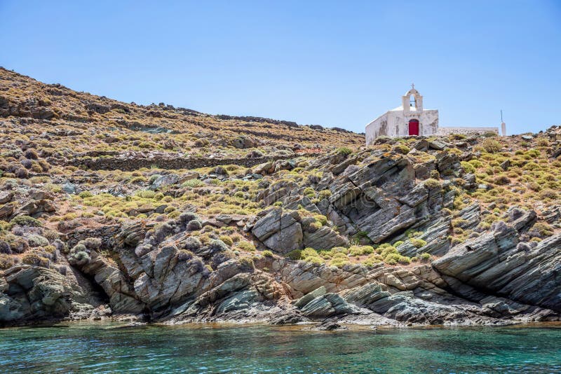 Small chapel, Greek Church on the rocky hill by the sea, blue sky background. Kythnos island, Greece
