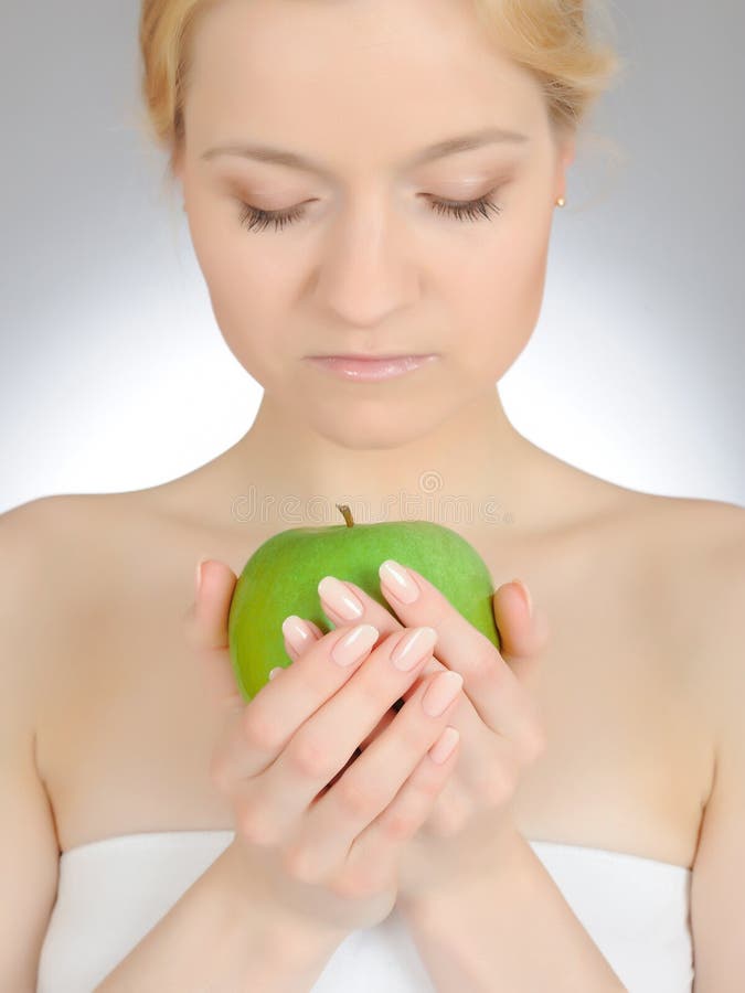 Green apple in beautiful manicured hand of woman