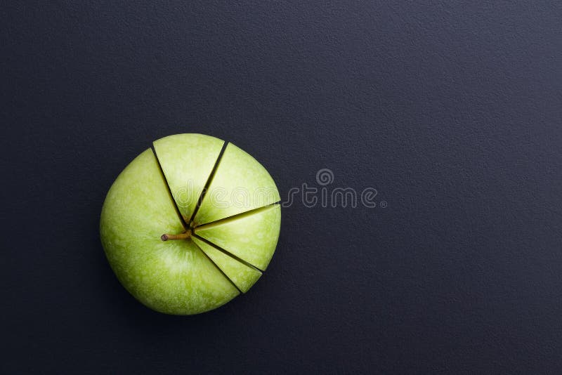 Green apple cutting in the shape of pie chart on back board. royalty free stock images Green apple cutting in the shape of pie chart on back board. royalty free stock images