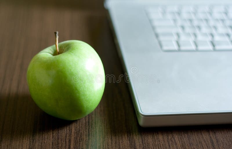 Green apple by laptop