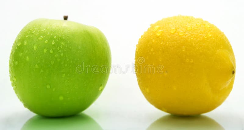 A green apple and a lemon with water drops