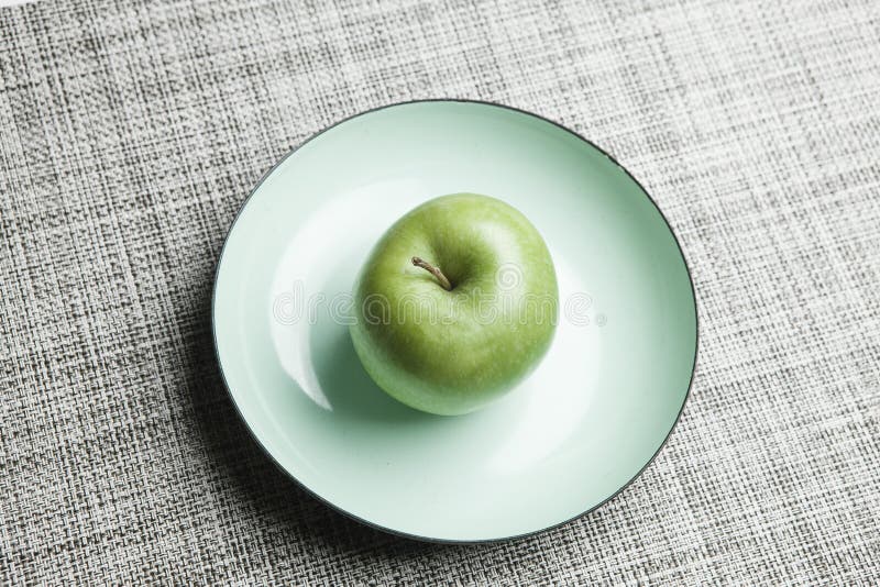 Green apple on plate stock photo. Image of textile, plates - 50499560