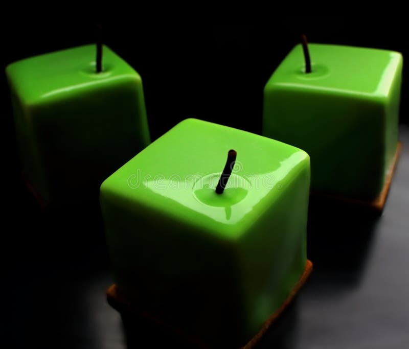 Green apple shiny glazed cube desserts on black background stock photography Green apple shiny glazed cube desserts on black background stock photography