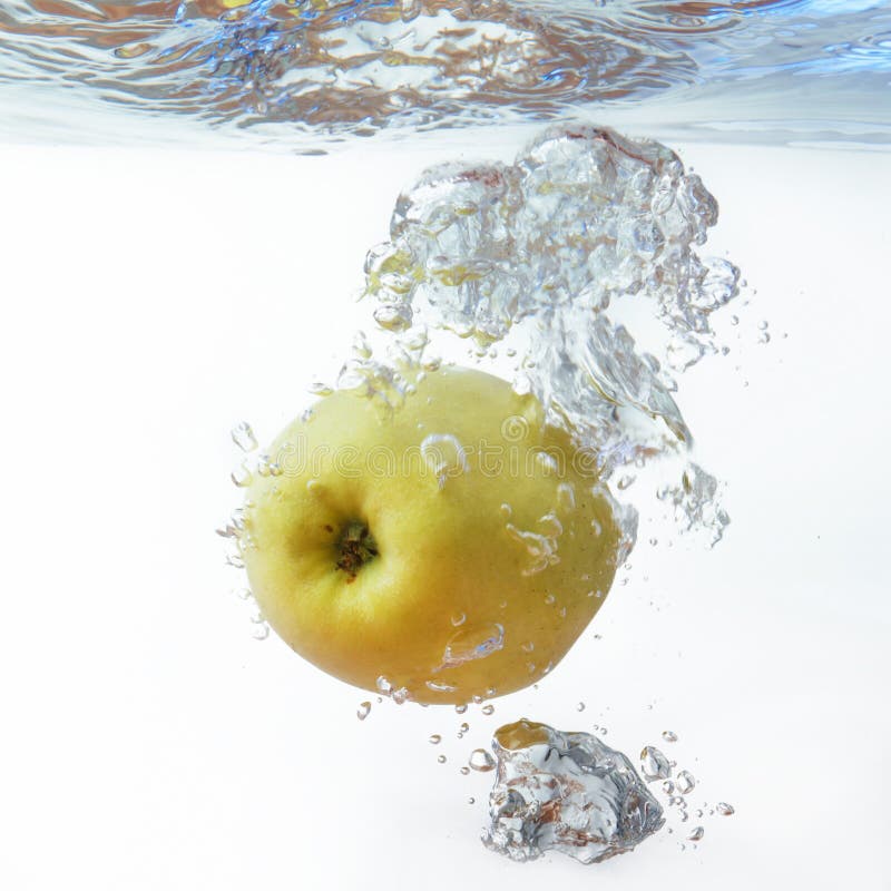 Green Apple Under Water with a Trail of Transparent Bubbles Stock Photo