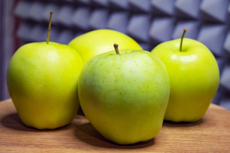Green apples on a wooden table, grey patterned backdrop royalty free stock photos