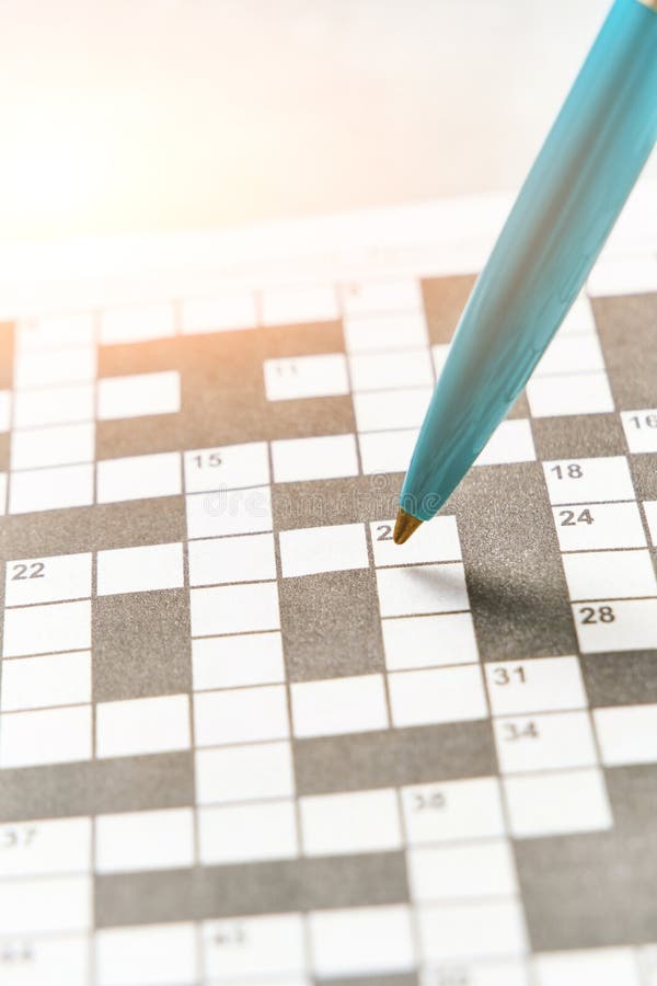 Ballpoint Pen on Background Crossword Puzzle Sheet in the Contoured