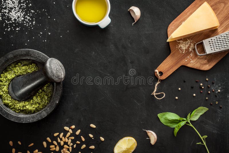 Green basil pesto - italian recipe ingredients on black chalkboard