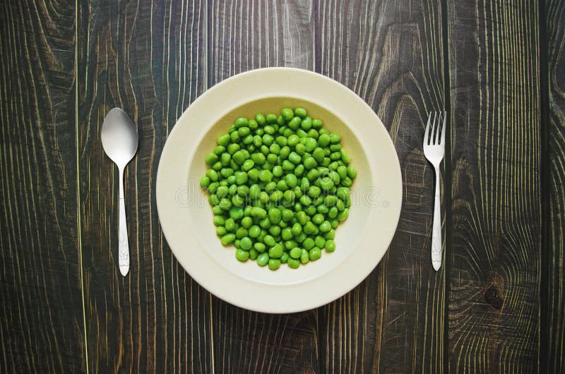 Green Bean on a Plate with Fork and Knife on the Side Stock Photo
