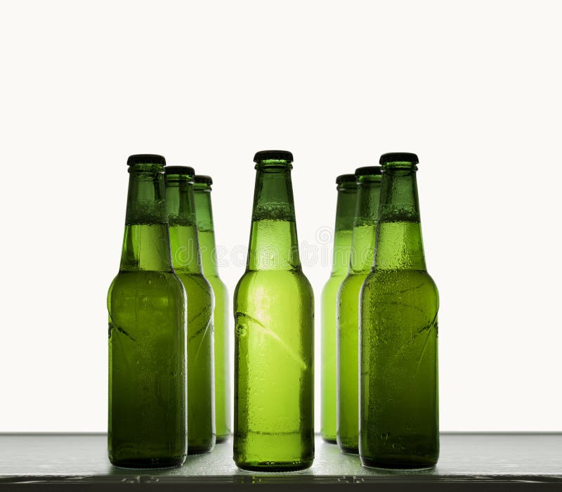 Green Beer Bottles Chilled in Water Drops on a Shelf on a Light