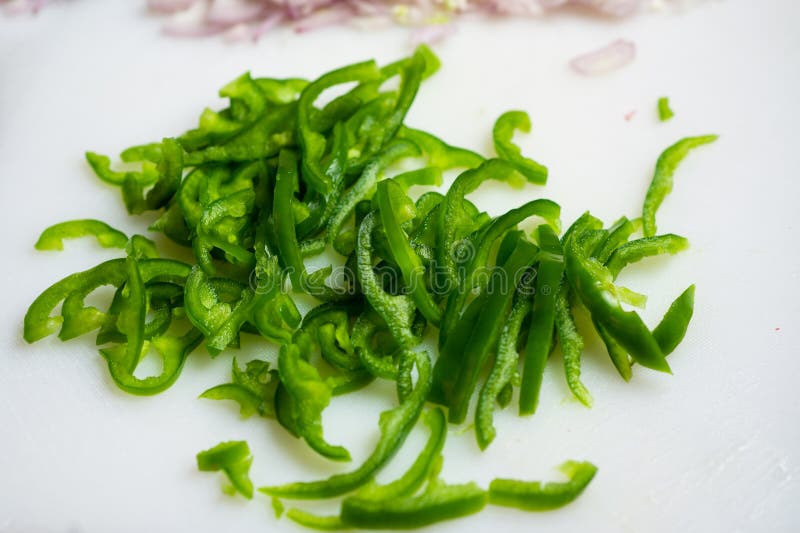 Green Bell Pepper Cut To Length on a White Cutting Board Stock Image