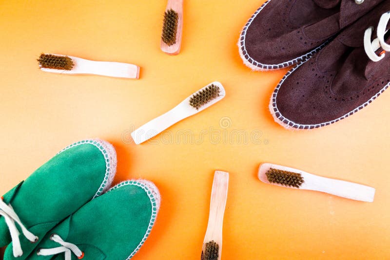 Green and brown suede espadrille shoes with brushes on yellow paper background.