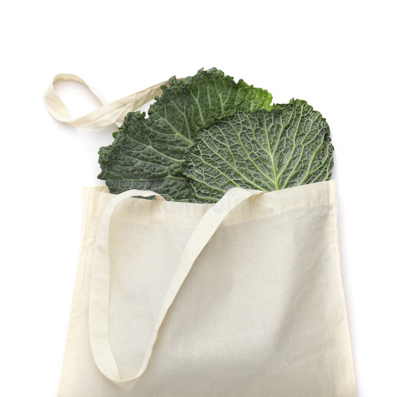 Green cabbage leaves in white cotton reusable shopping bag