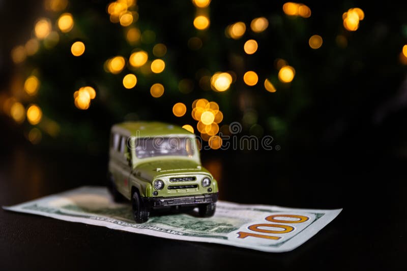 Green car and banknote United States One Hundred Dollar under the New Year tree stock photos Green car and banknote United States One Hundred Dollar under the New Year tree stock photos