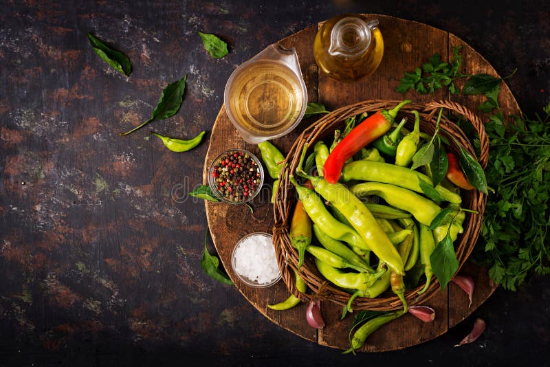 Green chili peppers in a basket on a dark background.