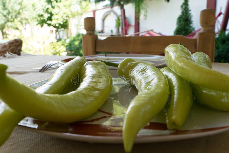 Green Chilli pepper on a garden table. Mediterranean food in a plate ready to eat. Raw Organic. Home Chair royalty free stock images Green Chilli pepper on a garden table. Mediterranean food in a plate ready to eat. Raw Organic. Home Chair royalty free stock images