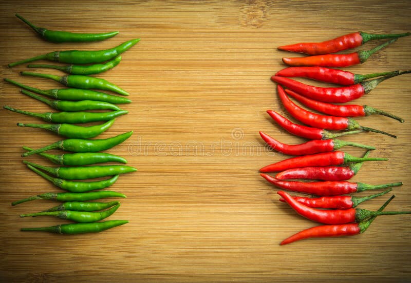 Green chilli pepper on Left side and Red chilli pepper on right side of chopping block