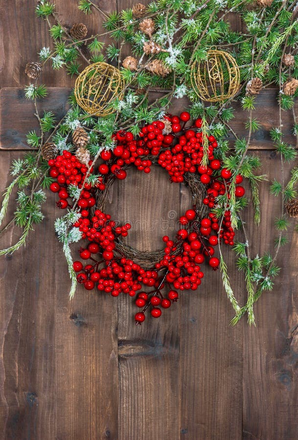 Green christmas tree branches and wreath from red berries