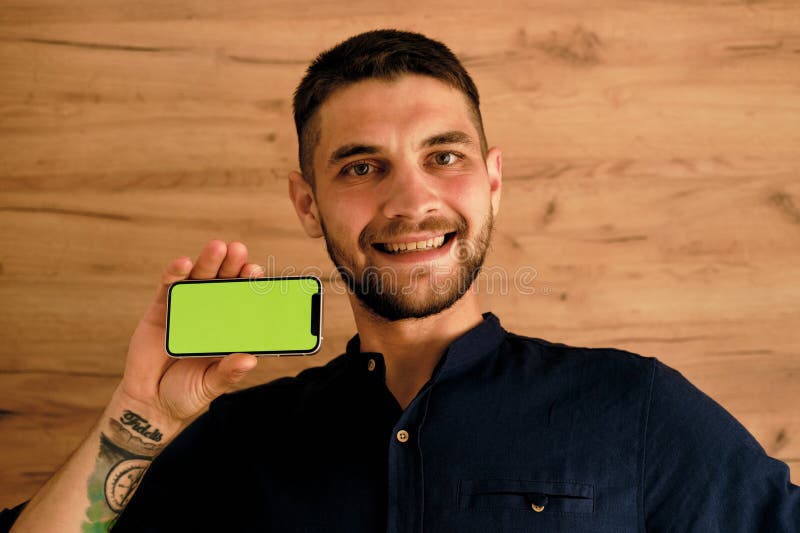 Green chromakey mock up image blank screen smartphone with copy space background for advertising text. Marketing and creative design concept. The young guy was surprised to see the image on the phone. Background chromakey copy space stock images, royalty-free photos and pictures