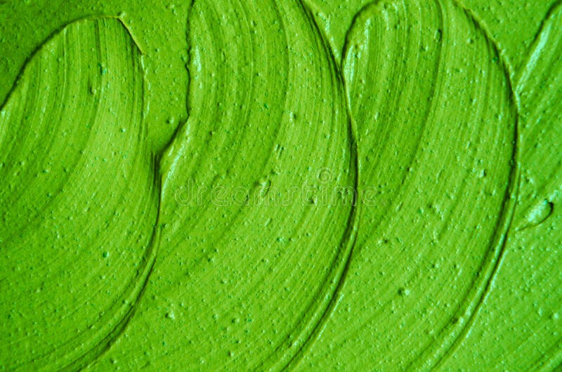 Green cosmetic clay facial mask, cream texture close up, selective focus. Abstract lime green background with brush strokes.