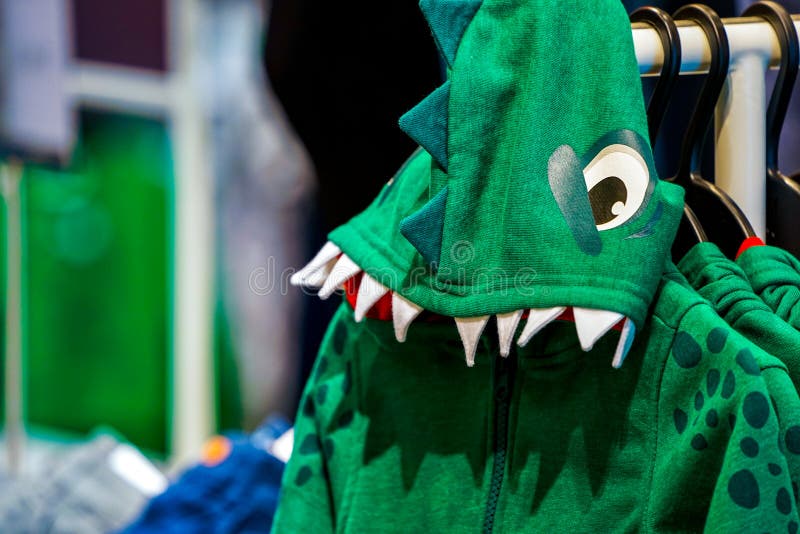 Green creative dragon or dinosaur costume sweater for children, Sales in the kids` fashion store stock image