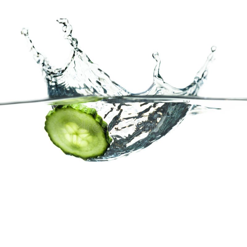 Green cucumber slice splashing in the water royalty free stock photo