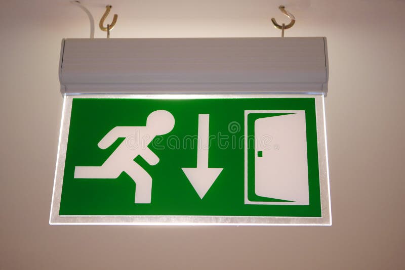 Green Evacuation Direction Sign on Ceiling. Emergency Exit Sign with