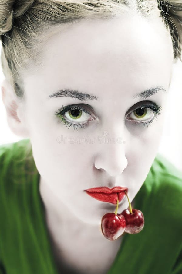 Green-eyed woman with cherries in the mouth stock image Green-eyed woman with cherries in the mouth stock image