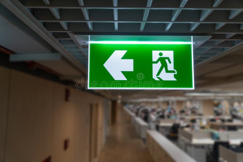 Green Fire Escape Sign Hang On The Ceiling In The Warehouse. The
