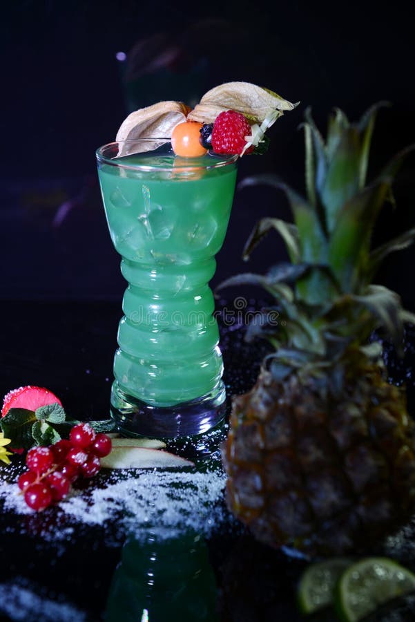 Neon green cocktail with fruits on black background royalty free stock photos Neon green cocktail with fruits on black background royalty free stock photos
