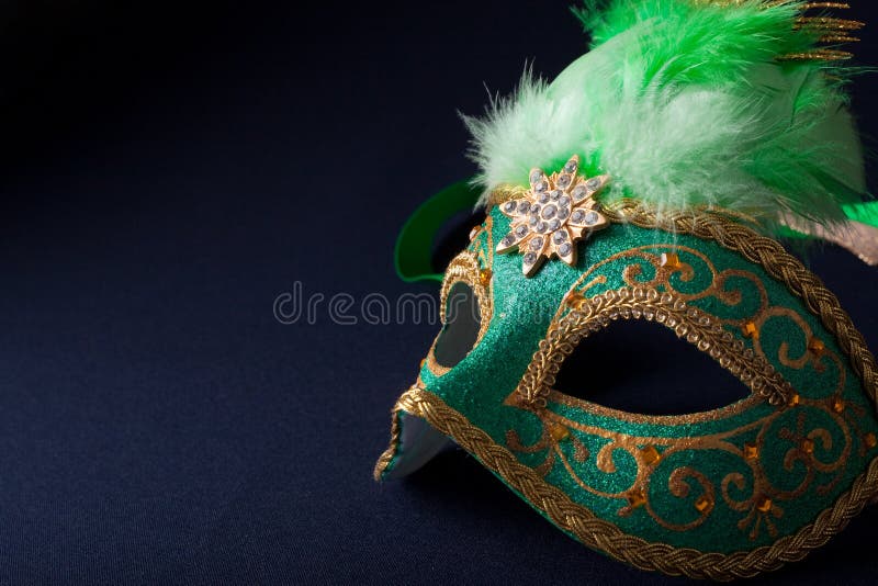 Green and gold mask on dark background