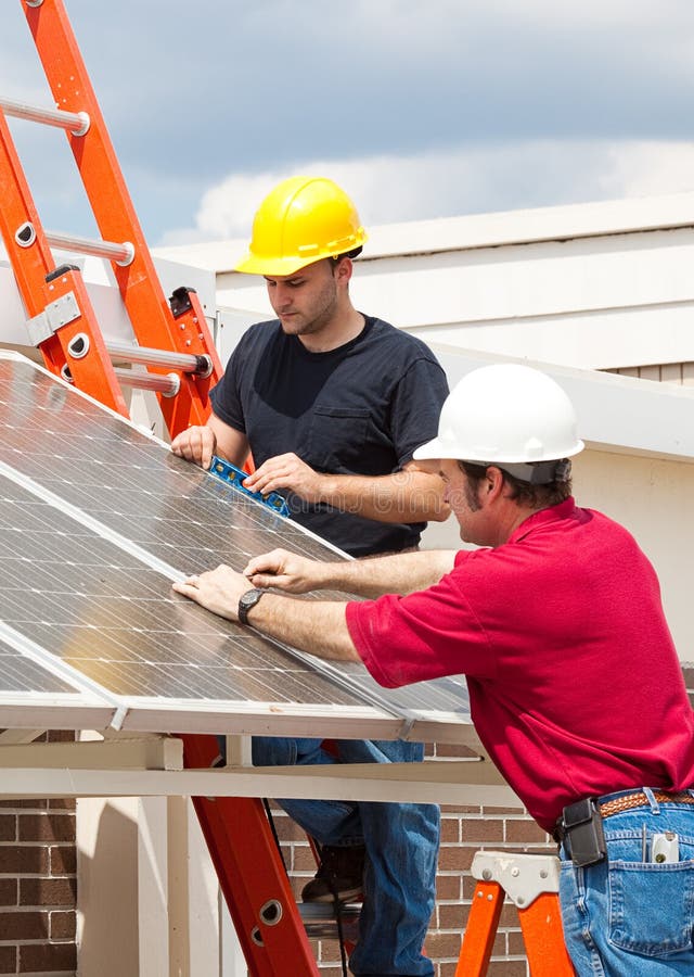 Electricistas en negocios sobre el instalar soleado paneles sobre el página de el edificio.