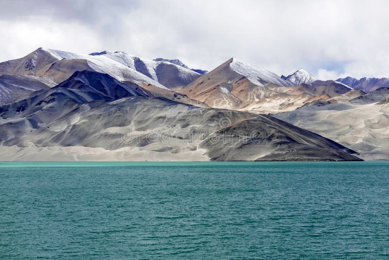 Green lake, snow mountain, white clouds, blue sky