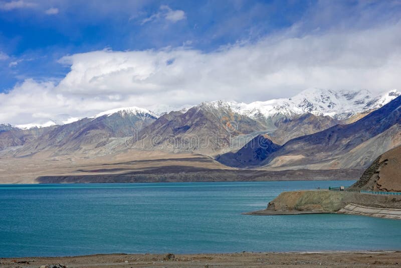 Green lake, snow mountain, white clouds, blue sky in Pamirrs