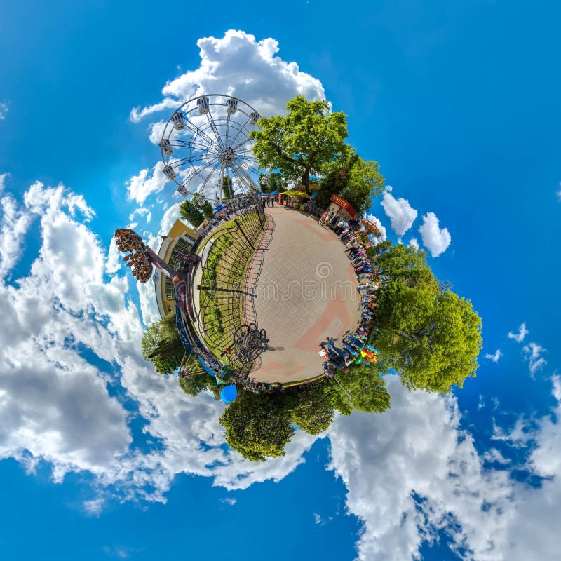Green little planet with trees, white cluds and soft blue sky. Tiny planet of amusement park. 360 viewing angel. stock photo