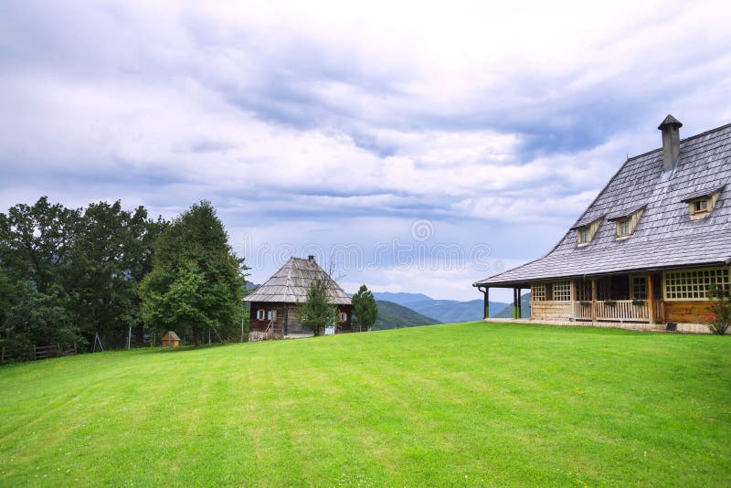 Green mown the lawn in front of a wooden house