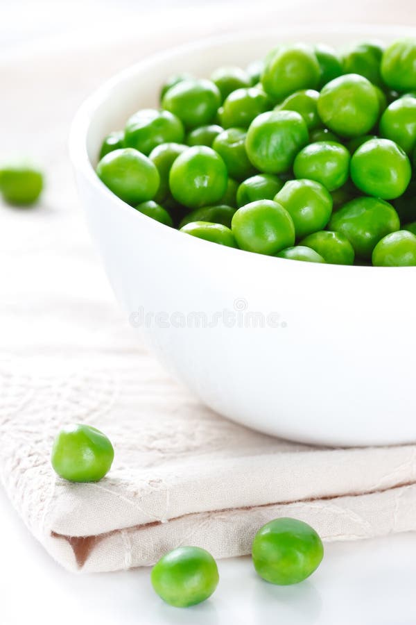 Green peas on a white ceramic bowl close-up. Green peas on a white ceramic bowl close-up.