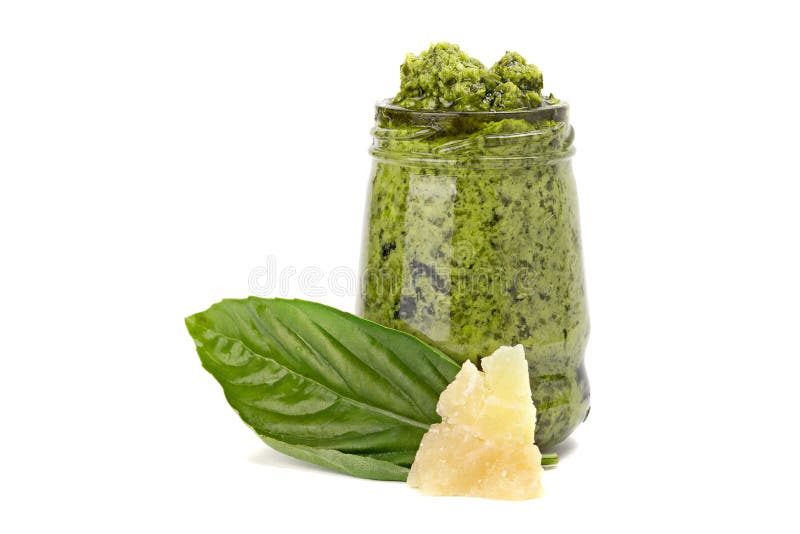 Green Pesto in the Glass with Piece of Cheese and Leaf of Basil Stock