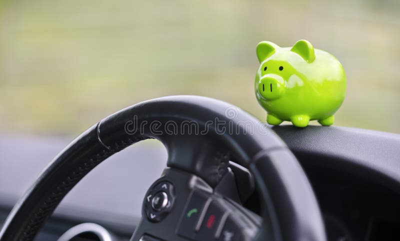 Green piggy banque boîte à argent à l'intérieur de voiture achat d'assurance ou de conduite et de conduite image libre de droits