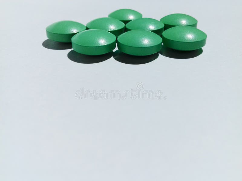 Green pills on a white background. 