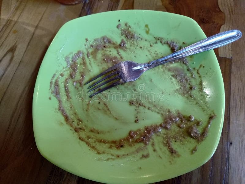 green plate left over with sauce and spoon on top royalty free stock photos green plate left over with sauce and spoon on top royalty free stock photos