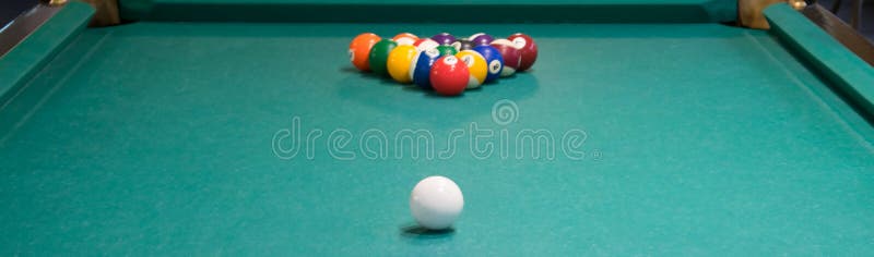 Green pool table, pyramid of balls to play, white ball to hit.