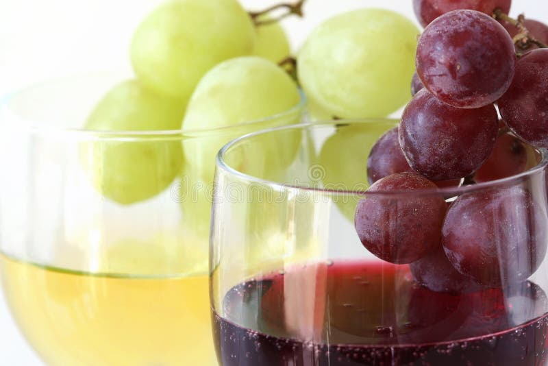 Green and red grapes on the white and red wine glasses