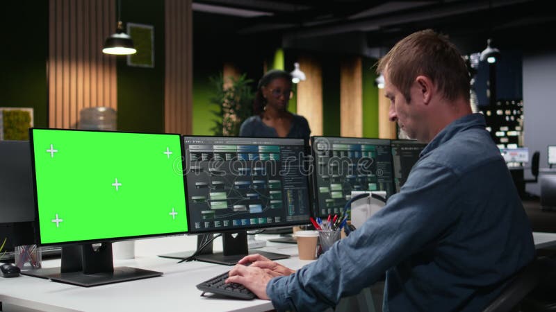 Green screen PC used by admin in office fixing artificial intelligence bugs stock video footage